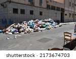 Small photo of PALERMO, ITALY - 06 18 2022: Mountain of household thrash on the sidewalk spilling into the street in the city centre of Palermo