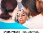 Small photo of Kharkiv, Kharkiv Oblast, Ukraine - 08 18 2021: Botox injection into mimic wrinkles on the forehead by a student under the supervision of a master beautician doctor in a cosmetology office. Learning