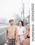 Small photo of Solo City, Central Java, Indonesia - May 27, 2021 : A happy couple taking pre-wedding photos wearing Javanese clothes