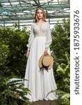 Small photo of Beautiful woman bride fashion model blond hair bright makeup pretty wear long silk white dress lace bridal ceremony wedding espousal in blooming romance garden party marriage accessory hat.