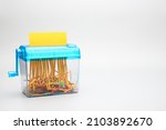blue hand shredder with yellow paper on white background with copy space