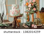 Cake on wooden stand with flowers and tubes of paint tubes, beautiful vintage room