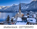 Snowy rooftops of Hallstatt, Austria with the Alpine ranges and the Hallstatt Lake in the background.