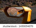 Looking at the rear view mirror in the desert. 