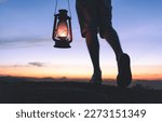 Small photo of Walking at night while carrying a kerosene lamp to light the way, with sky after sunset in the background. Taking steps on the path of faith and spirituality.