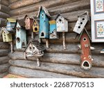 Several birdhouses on a wooden wall. Wooden birdhouses, a birdhouse for songbirds. Colorful Cute Birdhouses on a Rustic Wooden Wall. stock photo