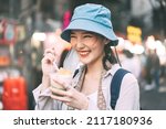 Small photo of Happy young adult asian foodie woman backpack traveller eating asia dessert. People traveling with new normal lifestyle at outdoor at China town street food market. Bangkok, Thailand