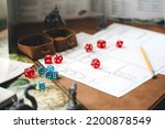 Small photo of Role playing tabletop and board games hobby concept. D20 dice place on character sheets for create begin fantasy and adventure. Background with book and miniatures.