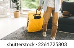 Small photo of People getting ready for holidays travel trip concept. Single traveler man walking carry a luggage begin a journey. Men wear casual cloth and sneakers. Background in living room at home or hotel.