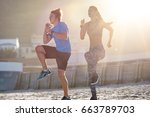 Fit active lifestyle, couple working out on beach with sun flare