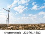 Small photo of Awe-inspiring view of a wind farm standing tall amidst the vastness of the Guajira Desert, harnessing the power of the sun and wind on a sunny day