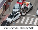 Small photo of improperly parked car being carried by a municipal tow truck