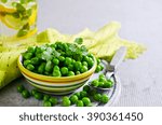 Green peas with mint in a bowl on a light background. Selective focus.