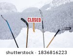 Closed sign with hockey sticks in the snow.Sport or venue closed due to bad weather or coronavirus.