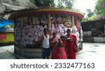 Small photo of Budge Budge, West Bengal, India- July 12 2023: Family praying to god for good health, peace and prosperity, People hang their wishing paper at the temple outside to get fulfilled their wishes.