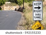 Sign to Keep Right thru tunnel on a paved urban bike path