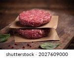 Raw ground beef meat burger steak cutlets on wooden background close up