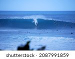 Small photo of Oahu, Hawaii, USA - December 4 2008: A surfer takes a drop on a big wave at Pipeline Beach on Oahu's North Shore.