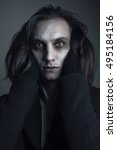 Small photo of Deranged caucasian male, long hair, crazy eyes and pale skin, British gothic