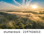 Airview light and shadows in mist. First rays of sun through fog and trees. Morning autumn landscape