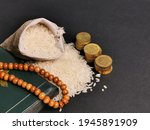 Small photo of Zakat concept. Selective focus rice in sack with coins,rosary and Koran. Zakat is a mandatory process for Muslims and is regarded as a form of worship.