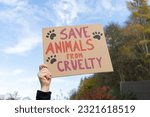 Small photo of Hand holding placard sign with text Save animals from cruelty, during animal rights march. Protestor with cardboard banner at protest rally demonstration.