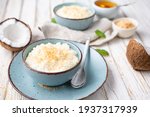 Small photo of Sweet and creamy coconut rice pudding with honey, topped with grated and toasted coconut in a ceramic bowl