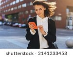 Beautiful Woman Going To Work With Mobile Phone, Business Woman Walking Near Office Building. Portrait Of Successful Business Woman.