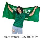 Small photo of Young soccer fanatic woman with green sports jersey and flag to Saudi Arabia in his hands, happy for the victory of his favorite team.