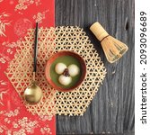 Small photo of Matcha Big Tangyuan (Tang Yuan) with Sweet Matcha Soup in Wooden Bowl on Black Wooden Table Background for Festival Food Winter Solstice. Top View