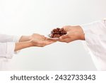 Concept Giving or Charity during Ramadhan Holy Month, Female Muslim Hand Over A Plate of Dates Fruit Kurma to Other. Ifthar and Ramadan Kareem Concept. 