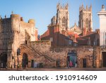 Small photo of York, England - February 25 2018: Afternoon golden light on the historic old town of York and ancient city walls at St. Leonard's Place looking towards York Minster Cathedral.