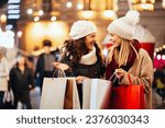 Happy women friends are shopping for presents at Christmas. People holiday sale shopping concept