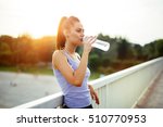 Woman drinking water after running to stay hydrated