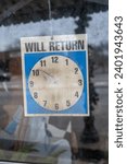 Small photo of A vintage storefront window with a prominent "Will Return" sign, its clock set to 10:51, capturing a moment frozen in time and resonating with a sense of bygone eras and urban charm.