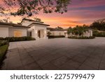 Small photo of Beautiful sunset shot of elegant backyard of mansion located in Villa Pinecrest, in Miami-Dade, Florida, with large tropical vegetation around, short grass, pool with spa, summer weather, trees, palm