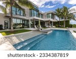 Florida, USA. Modern building with swimming pool, trees, chairs. Urban landscape with blue reflecting pool, city architecture, and scenic environment.