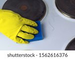Small photo of cleaning the electric stove with cleaning products in the kitchen at home. Household, household chores. Clean house, clean