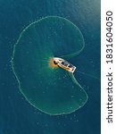 Small photo of Aerial view fisherman catching fish using net at the ocean.