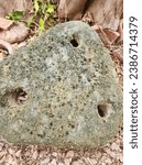 Small photo of Ancient anchor. Sea anchor. Stone anchor. Three round holes. Very heavy large anchor