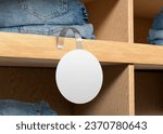 Small photo of white plain empty blank round branding store shelve wobbler label on wooden counter