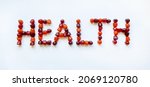Small photo of A group of red, orange and purple multivitamin gummies laid out in the form of the word health