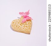 Small photo of Heart shape crumpet with spring inspired decorative element, creative love and passion layout, white background.