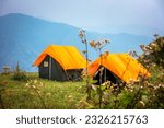 Small photo of Camps with orange outer fly on a Camp Ground. Nag Tibba, Himalayan region of Uttarakhand. Trekking And Camping