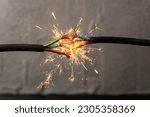 Small photo of sparks explosion between electrical cables, fire hazard concept, soft focus close up