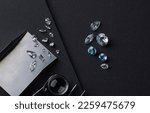 Small photo of Workplace of diamond expert in process of evaluating diamonds, top view black background.