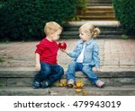 Group portrait of two white Caucasian cute adorable funny children toddlers sitting together sharing apple food, love friendship childhood concept, best friends forever