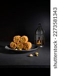 Small photo of Popular Arabic sweet- Baklava with a vintage Ramadan lantern on black background. Eating baklava during Ramadan is a tradition that goes back to the 15th century.