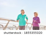 Small photo of Energize your life. Active mature family couple in sportswear smiling at each other while running together on a sunny morning. Joyful senior couple working out outdoors