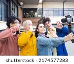 Group of funny young people recording a video with a camera for social networks. on the street. Young millennials who create digital content and influencers